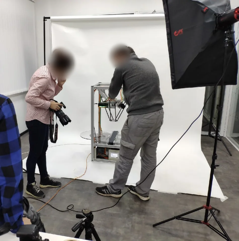 Robot delta do sortowania surowców wtórnych (prototyp). Twarze są rozmyte.